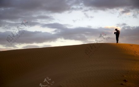 黄昏时在沙漠里孤独的人图片