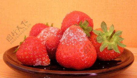 盘子里的草莓与白糖图片