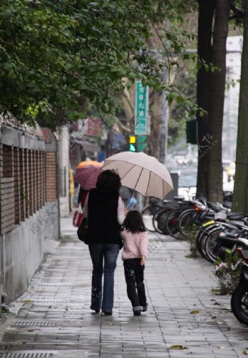 小女孩和母亲带着雨伞的背影图片