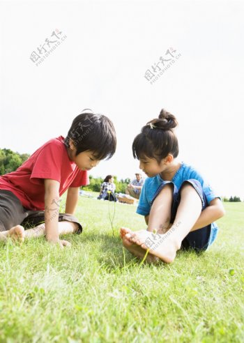 草地上玩耍的可爱男孩女孩图片