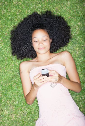 躺在草地上看手机短信的女生图片