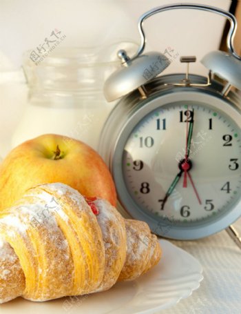时钟和羊角面包和苹果图片