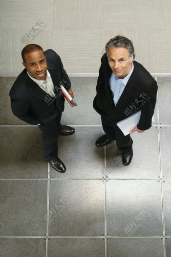 两个抱着文件的抬头看的商务男士图片