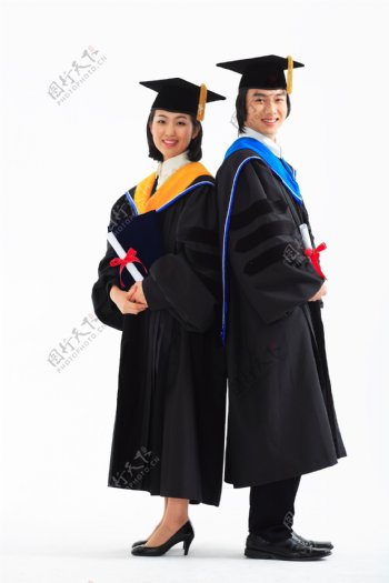 背靠着背穿着博士服拿着证书微笑的男女图片图片