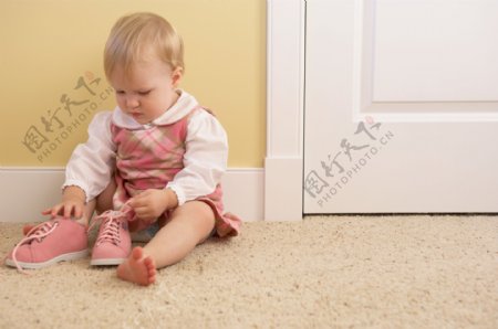 地毯上正在穿鞋的女孩图片