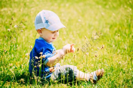 坐在草地上的小男孩图片