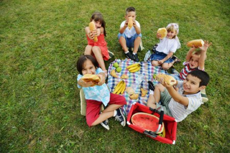 草地上吃食物的孩子图片