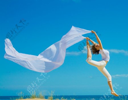 海边跳跃的外国美女摄影图片
