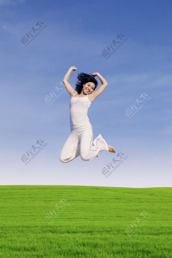 草地上跳起来的美女图片