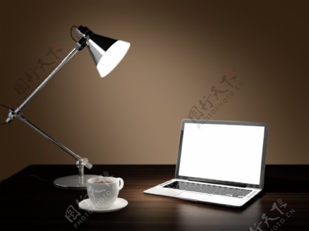 桌子上的电脑与台灯图片