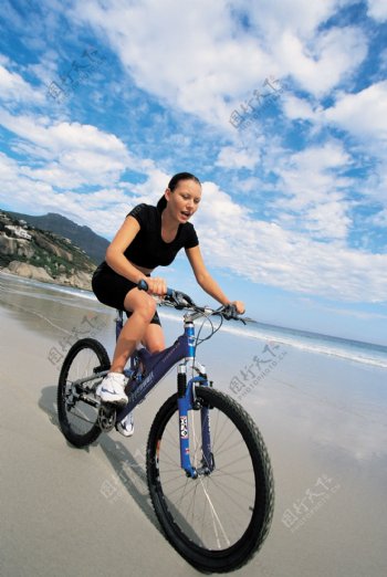 沙滩上骑自行车的美女