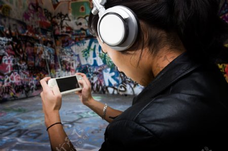 玩PSP游戏听音乐的时尚青年图片