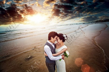 海滩上拥抱的婚纱情侣图片