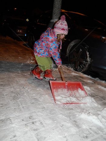 一个小女孩拿着铲子在铲雪