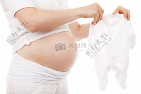 怀孕的女性拿着婴儿服装