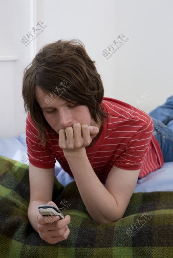 在床上看手机的男人图片
