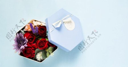 蓝色背景上装满花的礼物盒