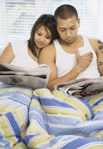 睡在床上看报纸的情侣图片