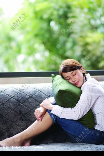 清纯少女坐沙发抱枕头图片