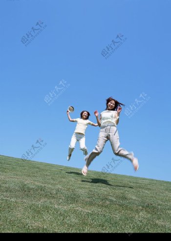 少女在草地上跳跃图片
