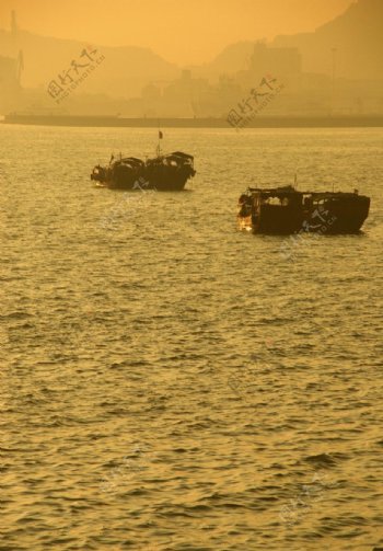夕阳下归港的渔船图片
