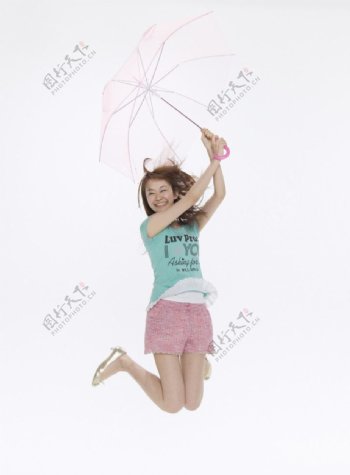 打着雨伞跳跃的女大学生图片