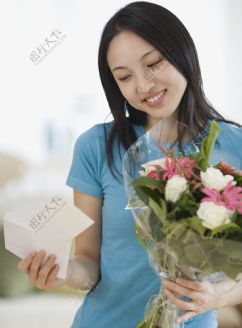 收到鲜花看留言的高兴美女图片
