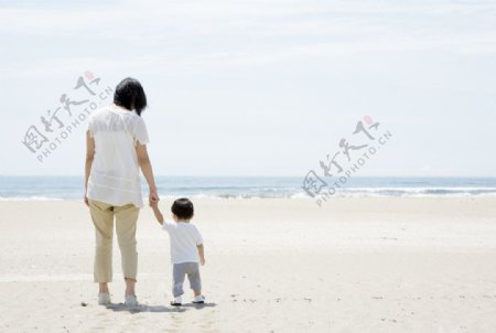 海滩沙滩散步的妈妈和孩子图片