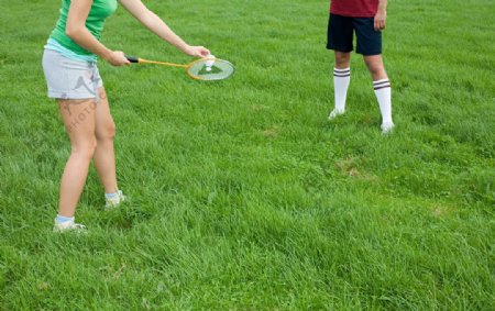 草地上打羽毛球的人腿部特写图片
