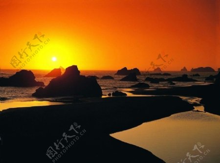 太阳照海边岩石图片