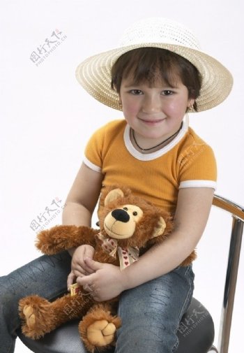 坐在椅子上抱着布娃娃的快乐孩子图片