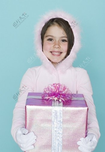 穿羽绒服手捧礼盒的甜蜜小女孩图片