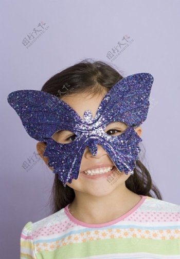 带着蝴蝶面具的灿烂小女孩图片