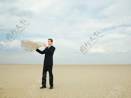 干旱地里手拿地图的外国男士图片