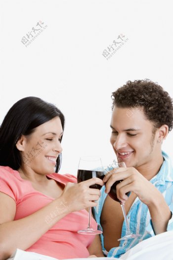 拿着红酒碰杯的亲密男女图片图片