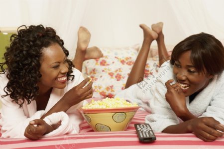 两个躺在床上吃爆米花的女人图片