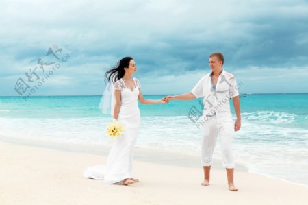 沙滩手牵手的新人夫妻图片