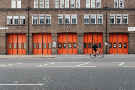 人骑自行车在布朗橙色砖楼前