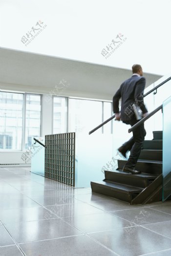 楼梯上奔跑的外国商业男人图片