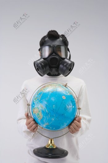 拿着地球仪戴防毒面具的男人图片图片