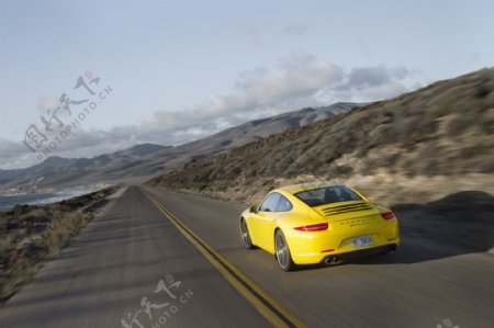 公路上行驶的黄色轿车图片