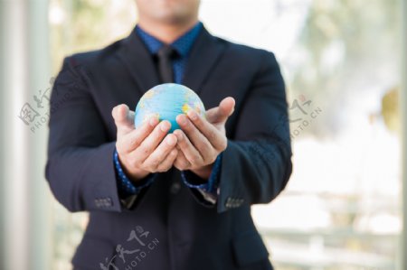 双手捧着地球的商务男人图片