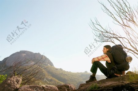 坐在石头上休息的男人图片