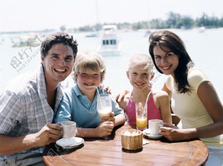 海边喝果汁的一家人图片