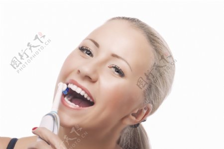 在用电动牙刷的女人图片