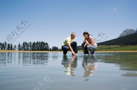 蹲在水面上的男女图片