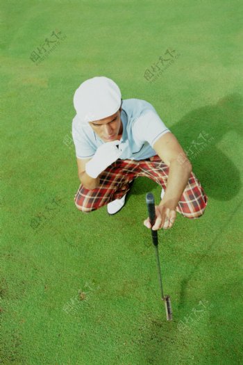 手拿高尔夫球杆的时尚男性图片