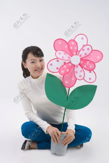 坐着的开心女人拿着花盆的图片