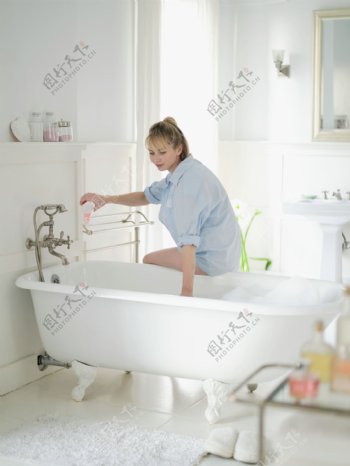 坐在浴缸边放水的女人图片