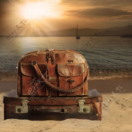日出海滩上的旅行箱图片